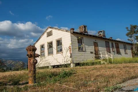 Abandoned building with an old fire hydrant in the foreground Stock Photos