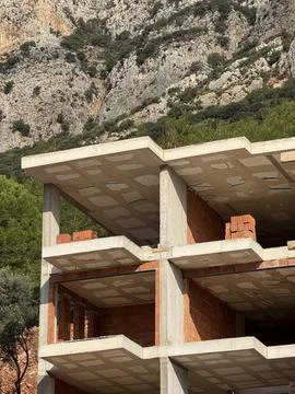 Abandoned building under construction with exposed brickwork against rocky .. Stock-Fotos