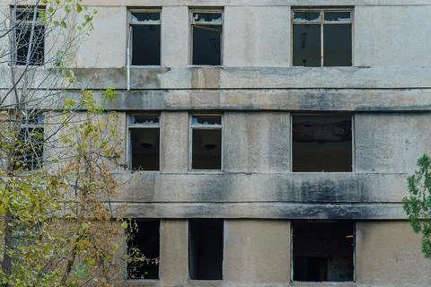 Abandoned building wall with broken windows Stock Photos