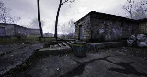 Abandoned buildings in a desolate landscape under overcast sky Ilustración de archivo