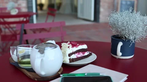Abandoned cake and tea suggest someone suddenly left the cafe table Stock Footage 345028811