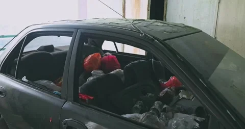 Abandoned car filled with trash, parking lot environment, urban decay Stock Footage 343557636