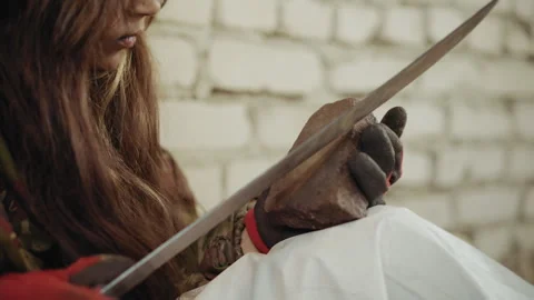 Abandoned Child Sharpens Blade on Stone in Cold Shelter Video stock 327463959