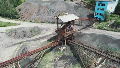 Abandoned coal mining facility with conveyor belts and machinery in a lush la Stock Footage 330696507