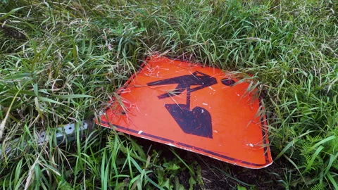 Abandoned Construction Orange Road Sign in Grass Panning Stock Footage 345529758