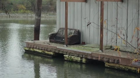 Abandoned couch sits on a weathered floating dock along the Sacramento River Stock Footage 324373347