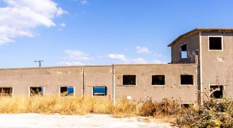 Abandoned derelict building with broken windows and weathered facade Stock Photos