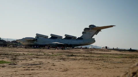 An abandoned ekranoplane stands on a sandy beach appears in the frame from Stock Footage 256018997