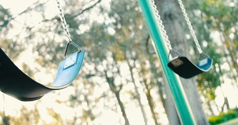 Abandoned empty child's swing sways in sunlight Stock Footage 63320150