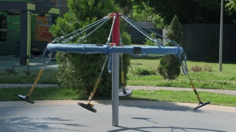 Abandoned empty swing with four seats in playground on summer sunny day Stock Footage 247898363