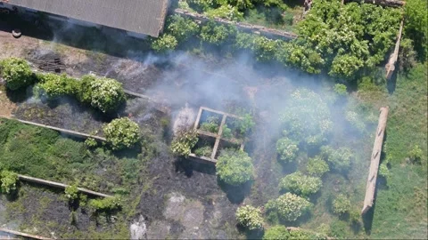 Abandoned farm buildings catch fire, igniting dry grass and producing heavy.. Stock Footage 276730792