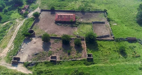 Abandoned farm structure with crumbling stone wall rural decay 4K aerial 스톡 동영상 85958577