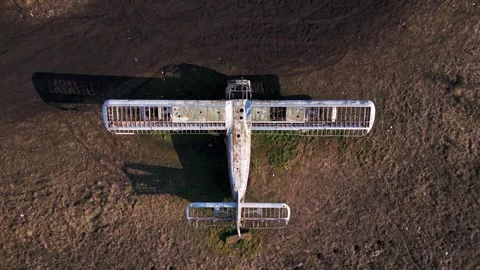 The abandoned frame of an Antonov An-2 rests on a grassy field. Its rusted Stock Footage 300068323