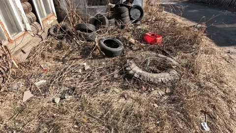 Abandoned garbage, tires, rubber, plastic, old wooden houses, siberia, tyumen Stock Footage 239147013