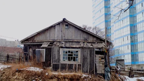  abandoned house on the background of a large, new multi-storey building. Stock Footage 126145337