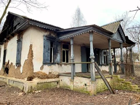 Abandoned house on an empty plot. Ruined building among trees and shrubs. Old Stock Photos
