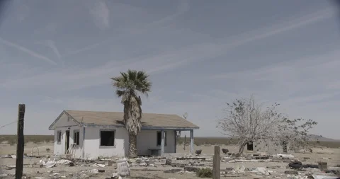 Abandoned House with Junk in Front Yard in Desert - Tilt Down Stock Footage 89943089
