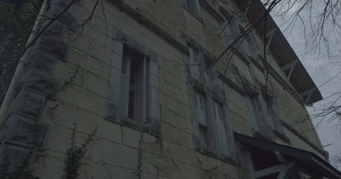 Abandoned house with Tree branches moving in the wind at night in a scary cloudy Video stock 110697843