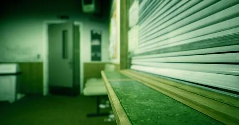 Abandoned interior of an empty room with a view of a closed shutter Stock Illustration