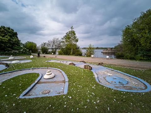 Abandoned mini golf course by a lake with swans Stock Photos