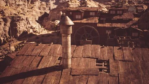 Abandoned mining town structures with weathered rooftops and a tower Illustrazione stock