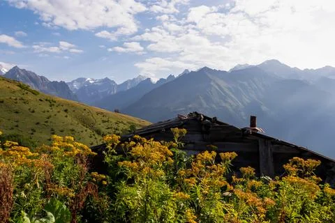 An abandoned mountain cottage with view on on the sharp Svaneti mountain pe.. Stock Photos