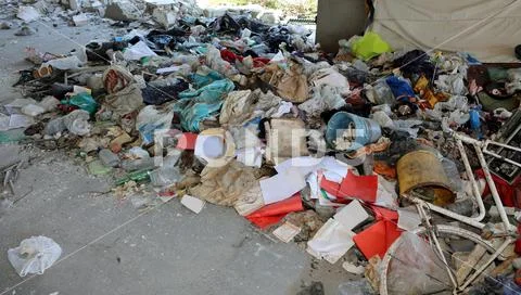 Abandoned objects after the eviction of homeless shelter with dirty tatters a Stock Photos