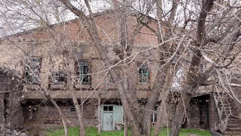 Abandoned old brick house with bare trees in front yard Stock Footage 345667343