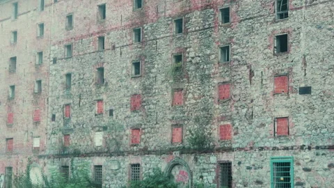 Abandoned old factory in rough condition next to a river Stock Footage 211461067