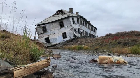 An abandoned old house on the shore of a small stream. Stock Footage 80266404