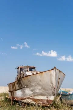Abandoned old rusty ship staying on the sea coast against blue sky in Byala Stock Photos