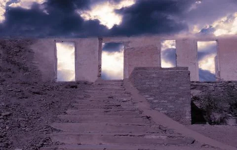 Abandoned old stone big wall with a staircase on a rock under a dramatic clou Stock Photos