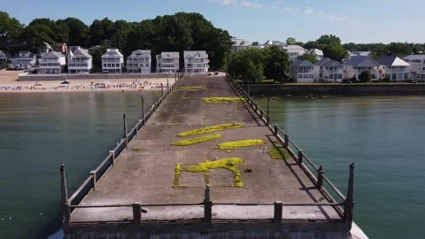 Abandoned Pier and Beach-side Homes on a bright sunny day Stock Footage 220899777