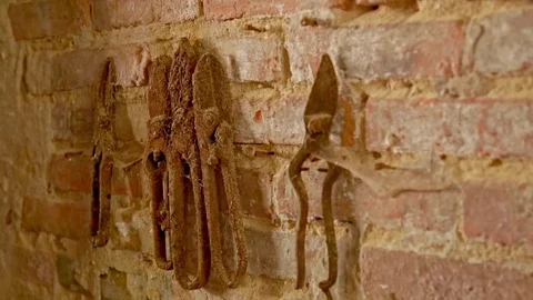 Abandoned place smithy. On a brick wall are rusty tools. Видео 80797793