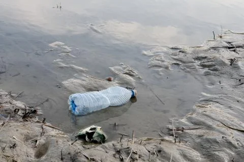 Abandoned plastic  bottle garbage at the river bank . Stock Photos