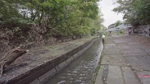 An abandoned polluted industrial stream on a cloudy day. Dolly view. Lybid river Stock Footage 162455788