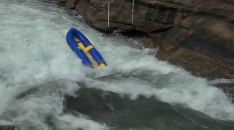 An abandoned raft stuck in river rapids Stock Footage 12249925