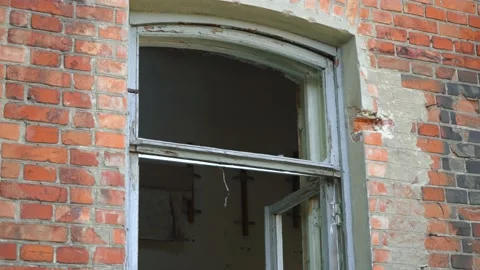 An abandoned red brick building with broken windows. Video stock 137300244