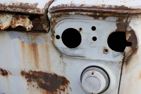 Abandoned rusty old car, back side of white car covered by rust Stock Photos