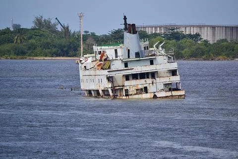 Abandoned rusty shipwreck sinking in the ocean near the shore Stock Photos