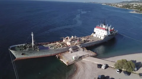 Abandoned ship docked at a remote shore during midday light 库存影片 301735399