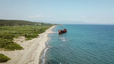 Abandoned ship rests on tranquil beach under clear blue sky Stock Footage 301735628