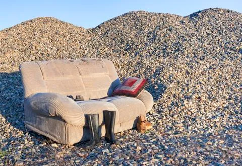 An abandoned sofa in a closed gravel pit that processed river stones. Foto stock