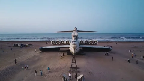 Abandoned Soviet Lun class ekranoplan sea coast sand beach tourist people Stock Footage 253877077
