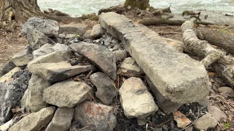 Abandoned Stone Firepit Sits by Rushing River Bank Stock Footage 333185825
