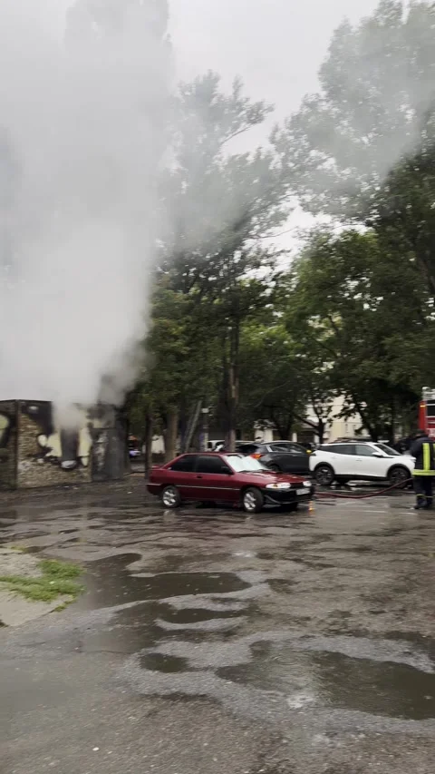 Abandoned store engulfed in flames while firefighters respond in a rainy urban 動画素材 317263542