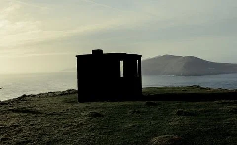 An abandoned structure by the sea at sunset, showcasing its journey through time Stock Photos