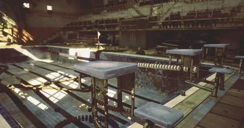 Abandoned swimming pool with sunlight casting shadows in a derelict building Ilustración de archivo