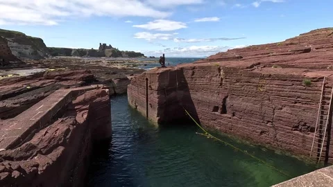 Abandoned tiny harbour carved into Gegan Rock at Seacliff, Scotland Stock Footage 313122467