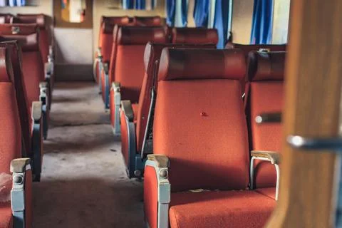 Abandoned train cabin, interior with red damaged armchair inside the train. Foto stock